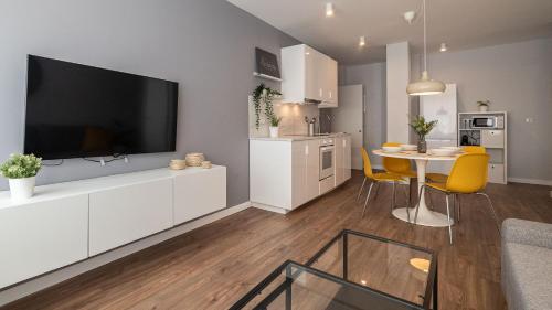 a living room with a large television on a white cabinet at Apartamento Luis de Vargas in Huelva