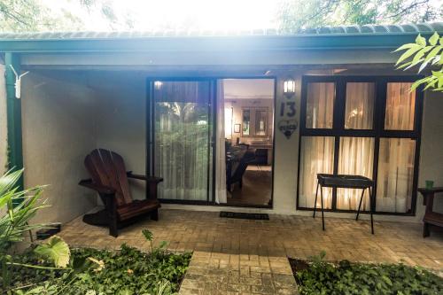 a screened in porch with a chair and a table at Winterton Country Lodge @ Rose Cottage in Winterton