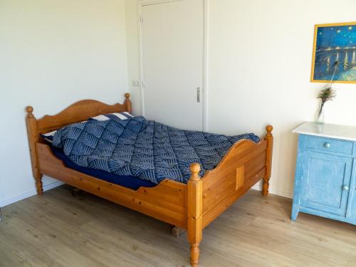 1 dormitorio con cama de madera y armario azul en Recreatieboerderij Hoeve Noordveld, en Oude Bildtzijl