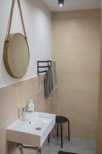 a bathroom with a sink and a mirror and a stool at Domki na Zaciszu in Lesko