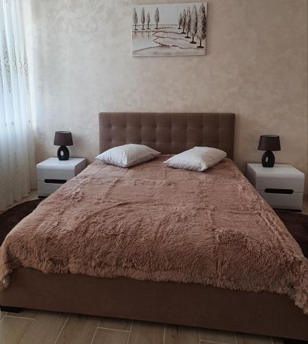 a bedroom with a large bed with two night stands at апартаменти квартира in Chortkiv