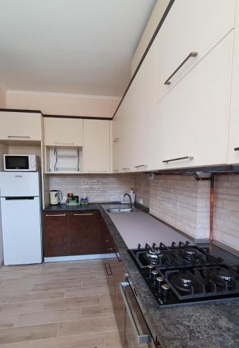 eine Küche mit einem Herd und einem weißen Kühlschrank in der Unterkunft апартаменти квартира in Chortkiv