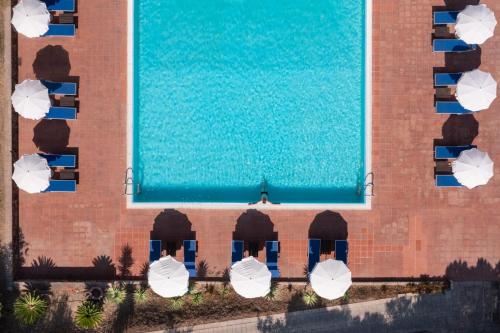 una vista aérea de una piscina con sombrillas en Eco Village Baia Delle Ginestre, en Teulada