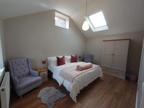 um quarto com uma cama e uma cadeira azul em Old Brewery Barn, Ullswater, Lake District em Penrith