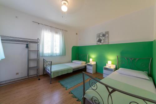 ミルナにあるHouse Ankaの緑の壁の客室で、ベッド2台が備わります。