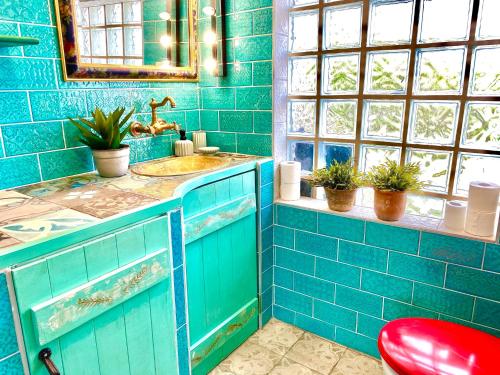a blue tiled bathroom with a sink and a mirror at Mexican style chalett at lake Balaton in Kisapáti