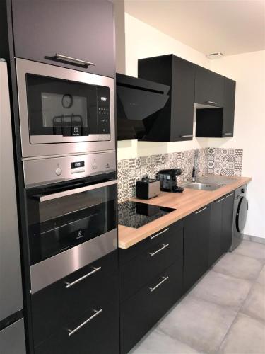 La cuisine est équipée d'un four micro-ondes et d'un évier. dans l'établissement Hyper-centre Reims Climatisation Rénové, à Reims