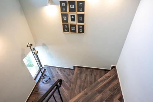 a staircase with wood floors and a light fixture at ТАНГЕНТА стаи за гости in Oreshak