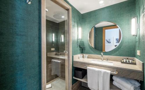 uma casa de banho com um lavatório e um espelho em Soho Boutique Equitativa em Málaga