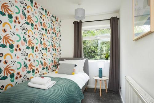 une chambre avec un lit avec un papier peint fleuri dans l'établissement Fantastic 3 bedroom property, à Halifax