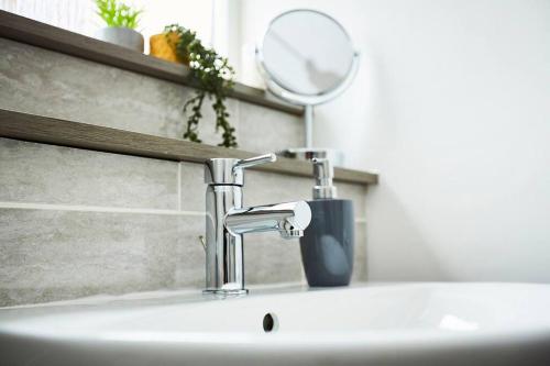 un lavabo de salle de bain avec un robinet et un miroir dans l'établissement Fantastic 3 bedroom property, à Halifax