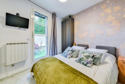 - une chambre avec un lit et une télévision murale dans l'établissement La Providence, à Nice