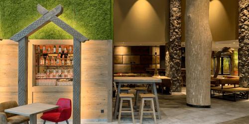 a restaurant with a bar with tables and chairs at Ostseehotel Midgard in Damp in Damp