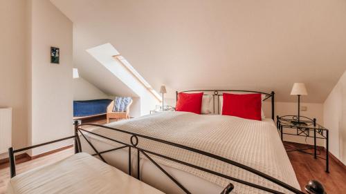 - une chambre avec un lit et des oreillers rouges dans l'établissement Wintergartenhaus Braunlage, à Braunlage