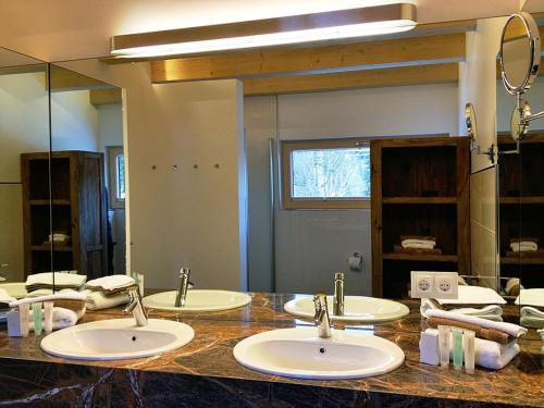 a bathroom with three sinks and a large mirror at Ferienhaus Alpenflair bei Schliersee in Schliersee