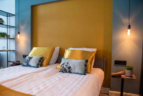ein Schlafzimmer mit einem großen Bett mit gelben und blauen Kissen in der Unterkunft B and B Suite No.3 in Gorinchem
