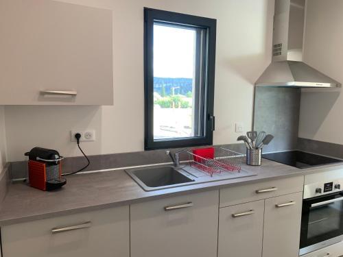 a kitchen with a sink and a window at ENTRE RIVIERE ET FORET in Vallon-Pont-dʼArc