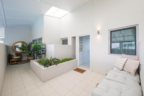 a living room with a white couch and plants at at Marina Shores in Airlie Beach