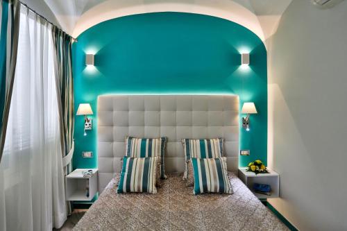 a bedroom with a bed with a blue wall at Apartments Amalfi Design in Amalfi