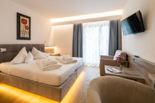 a hotel room with a bed and a chair at Familienhotel Post in Millstatt