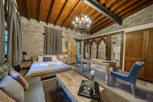 a bedroom with a bed and a table and a couch at Oinou Strata - Adults Only in Vouni