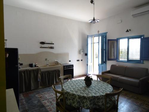 uma sala de estar com uma mesa e um sofá em Porta dei Mari em Ispica