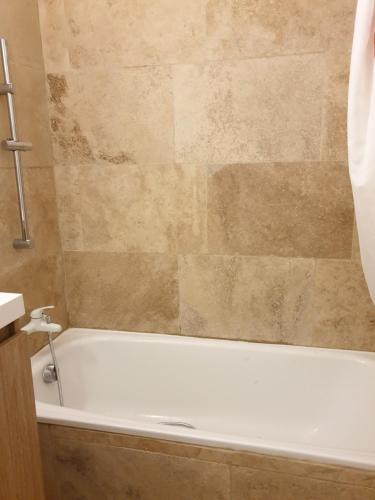 La salle de bains est pourvue d'une baignoire blanche. dans l'établissement Park Fabron 2 Pieces Terrasse Piscine Parking, à Nice