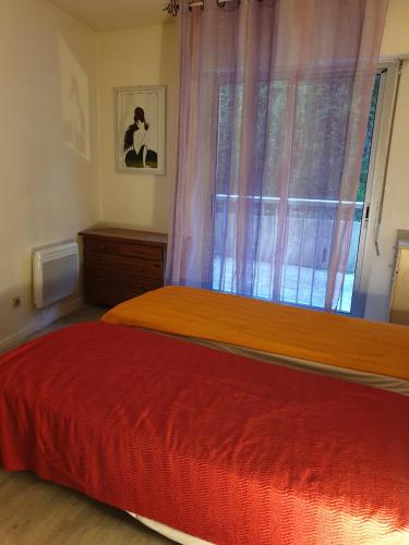 une chambre avec deux lits et une fenêtre dans l'établissement Park Fabron 2 Pieces Terrasse Piscine Parking, à Nice