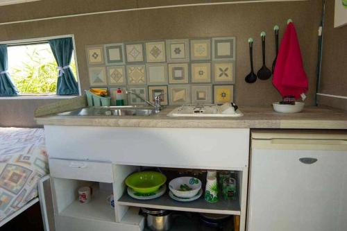 a kitchen with a sink and a counter top at JABUTI Autocaravana con porche y aparcamiento in Cádiz