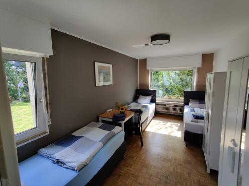 een slaapkamer met 2 bedden en een bureau. bij Schaefer Apartments - Villa Bischof in Offenbach