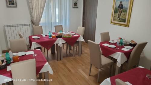 a dining room with tables and chairs with red table cloth at Agriturismo Macchia dei briganti - b&b in Montefalcione