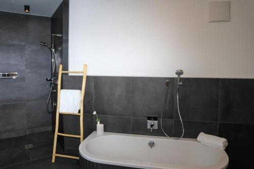 a bath tub in a bathroom with a light on the wall at Apartment in Bramberg near Cable Car in Bramberg am Wildkogel