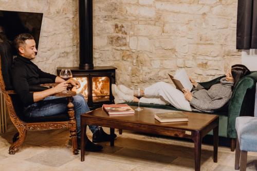 a group of people sitting in a living room with a fireplace at Oinou Strata - Adults Only in Vouni