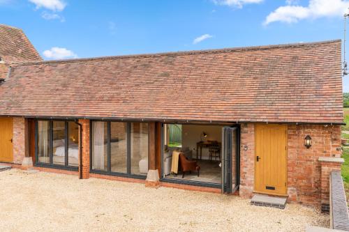 an external view of a brick house with large windows at Swifts Retreat in Bidford