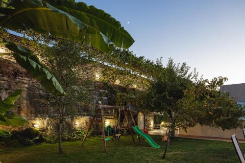 a backyard with a swing set in the yard at Lilium Villa, summer aroma, By ThinkVilla in Perama