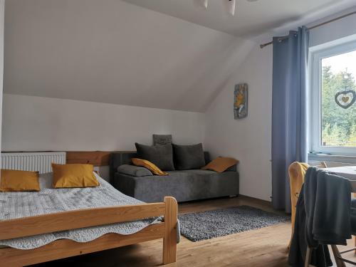 a bedroom with a bed and a couch at Apartamenty Grosik in Krynica Zdrój