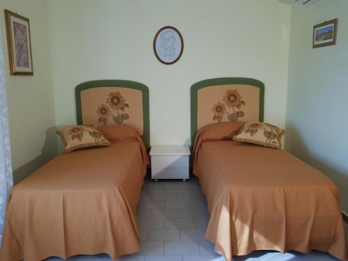 2 letti in una camera con orologio a parete di Top bedroom GOLFO - Le Lincelle, Lamezia - 2 extra large single beds a SantʼEufemia Lamezia