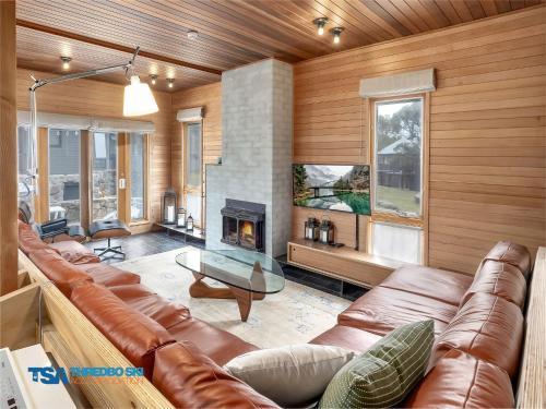 a living room with a couch and a fireplace at Milkwood 3 Chalet in Thredbo