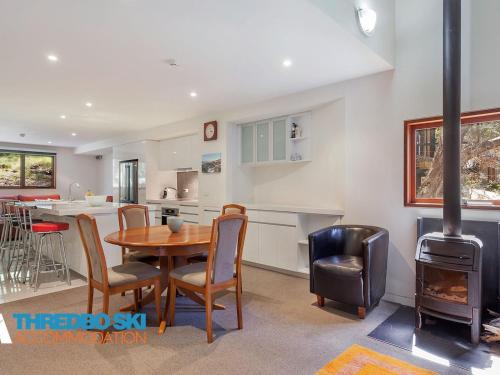 a kitchen and dining room with a table and a stove at Mosswood 4 in Thredbo
