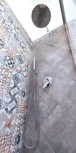 a shower with a hose on the floor of a bathroom at Appartamento con incantevole panorama in Bacoli