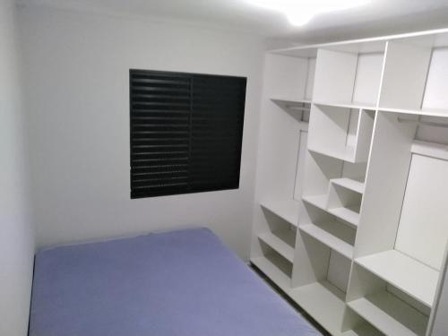 Cette chambre blanche dispose d'un lit et d'une fenêtre. dans l'établissement LA15-Bertioga, Próximo ao SESC, Riviera, Vista Linda, Indaiá, à Bertioga