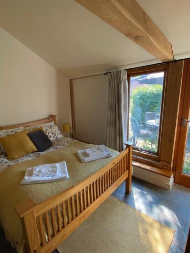 a bedroom with a bed and a large window at The Hop Barn in Staplehurst