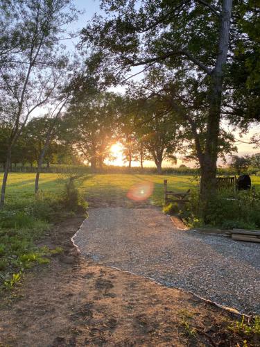 a path in a park with the sunset in the background at The Hop Barn in Staplehurst