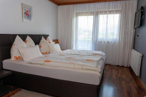 1 dormitorio con 1 cama grande y ventana en Appartement Fersterer/Schönblick, en Maishofen
