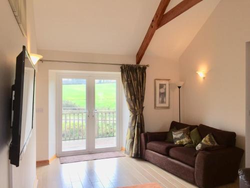 a living room with a couch and a sliding glass door at Cosy Cottages in Llandeilo