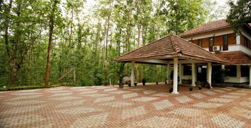 a pavilion in front of a building with trees at KTDC Tamarind, Nilambur in Nilambūr