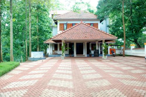 a house with a brick driveway in front of it at KTDC Tamarind, Nilambur in Nilambūr