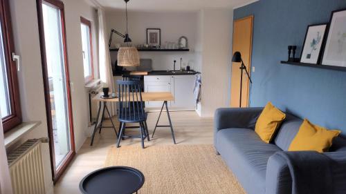 a living room with a blue couch and a kitchen at Hochwald-Balkon in Bad Sachsa