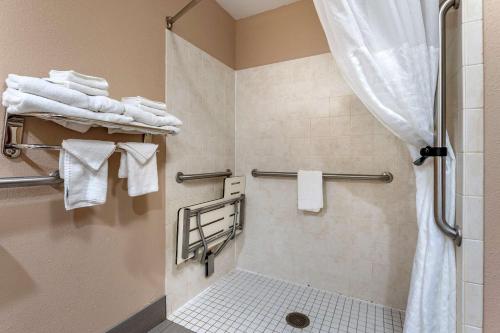 uma casa de banho com um chuveiro e toalhas brancas em Comfort Inn & Suites em Lawrenceburg