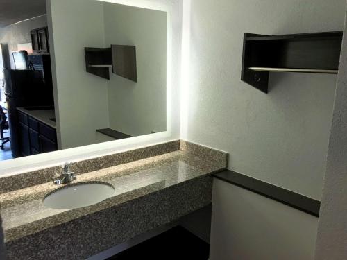 La salle de bains est pourvue d'un lavabo et d'un miroir. dans l'établissement Suburban Studios North Charleston I-526, à Charleston